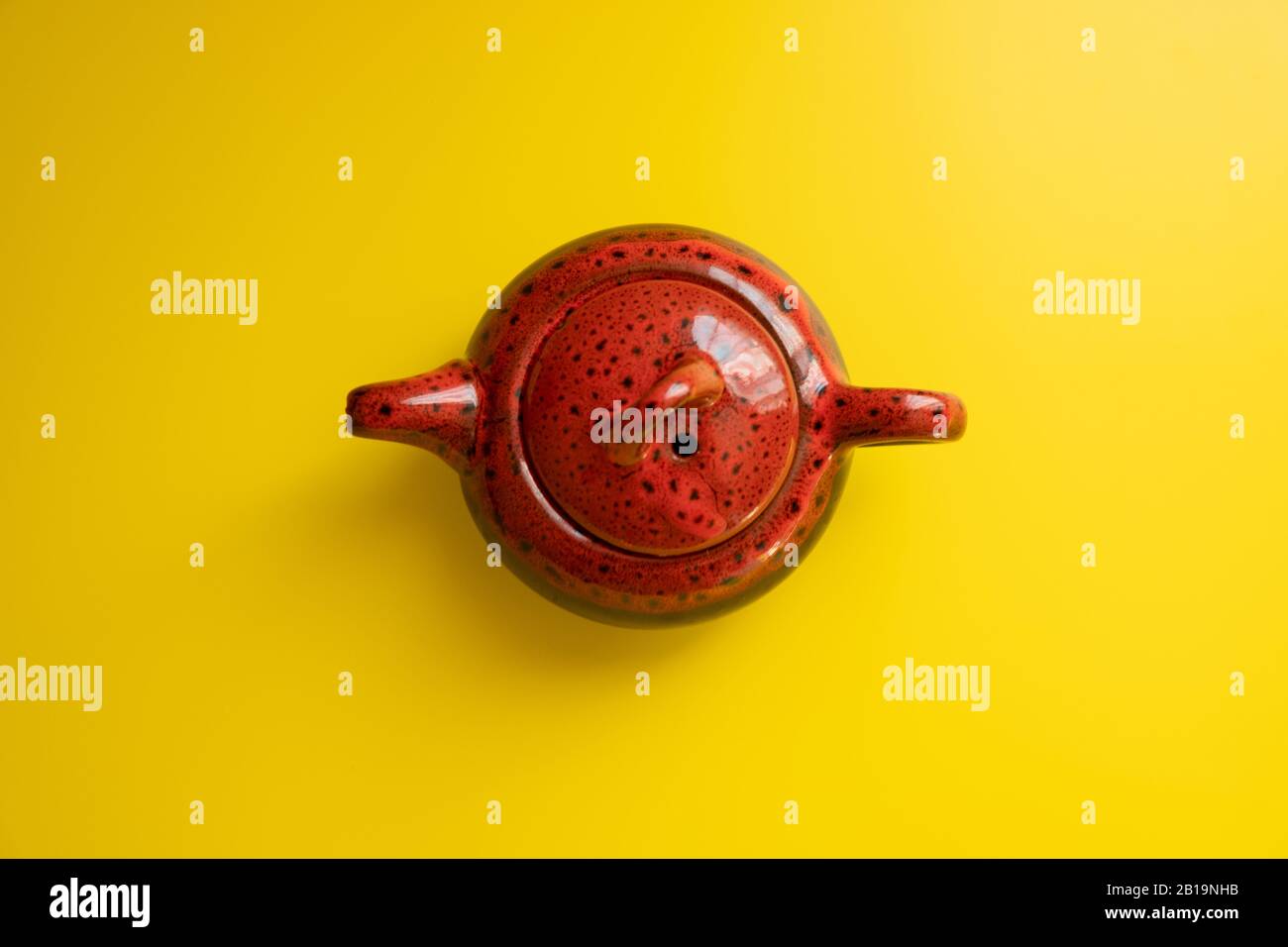 Teapot cinese marrone su uno sfondo giallo brillante vista dall'alto, minimalismo Foto Stock