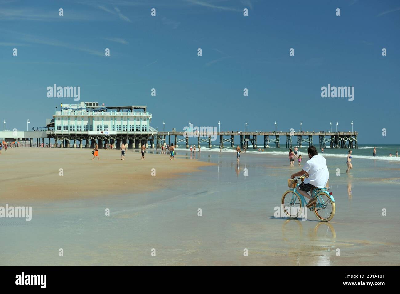Uomo in bicicletta a Daytona Beach, con Daytona Beach Pier sullo sfondo.  Daytona Beach, Florida, Stati Uniti Foto stock - Alamy