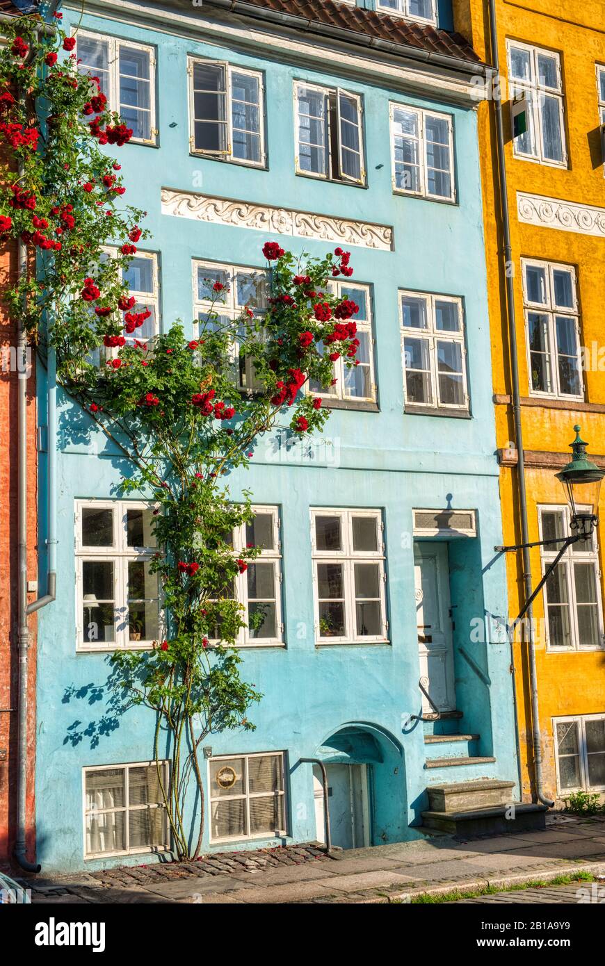 Edificio colorato a Copenhagen con rose di fronte Foto Stock