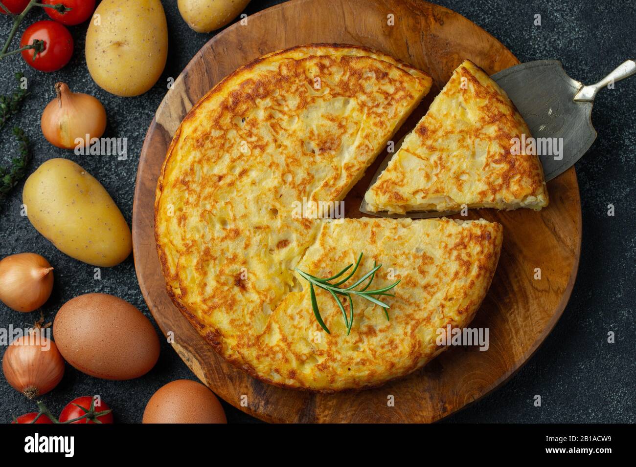 Frittata spagnola con patate e cipolla, cucina tipica spagnola. Tortilla espanola. Rustico sfondo scuro. Vista dall'alto Foto Stock
