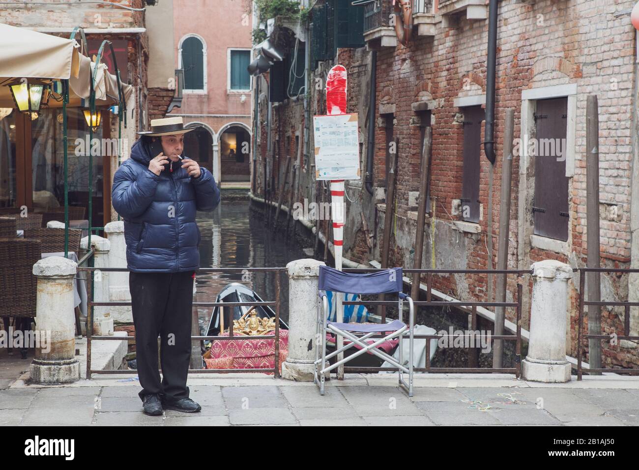 Un Gondoliere veneziano effettua una telefonata e ha un fumo durante una pausa Foto Stock