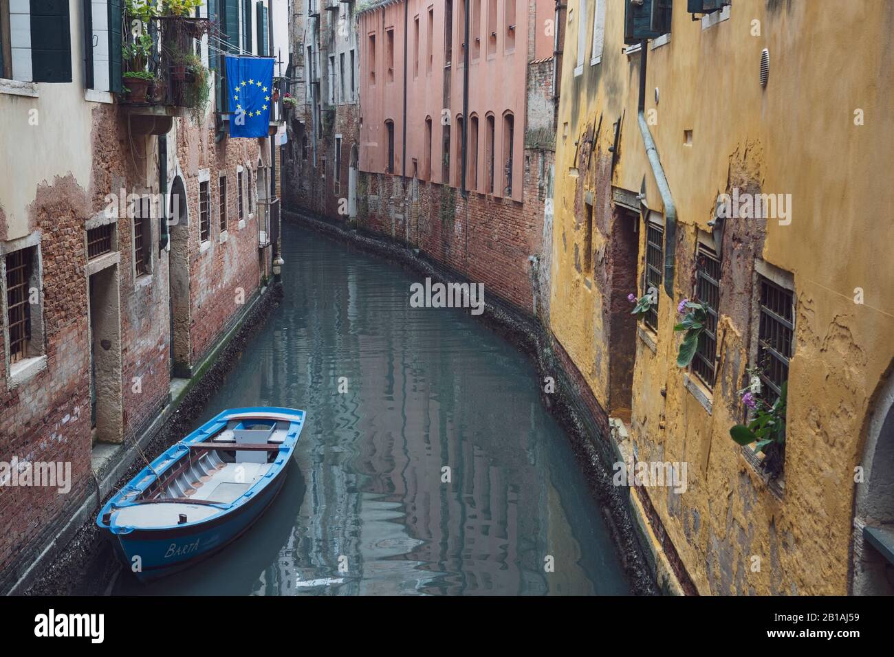 Una bandiera dell'UE vola da un edificio accanto a un canale senza persone a Venezia, Italia Foto Stock