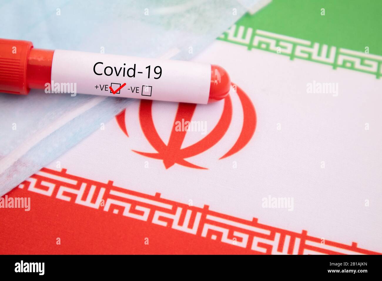 Maschera prevenzione Della Malattia respiratoria Causata da Covid-19, Coronavirus o nCov 2019 maschera Protettiva con campione di sangue positivo sulla bandiera iraniana Foto Stock