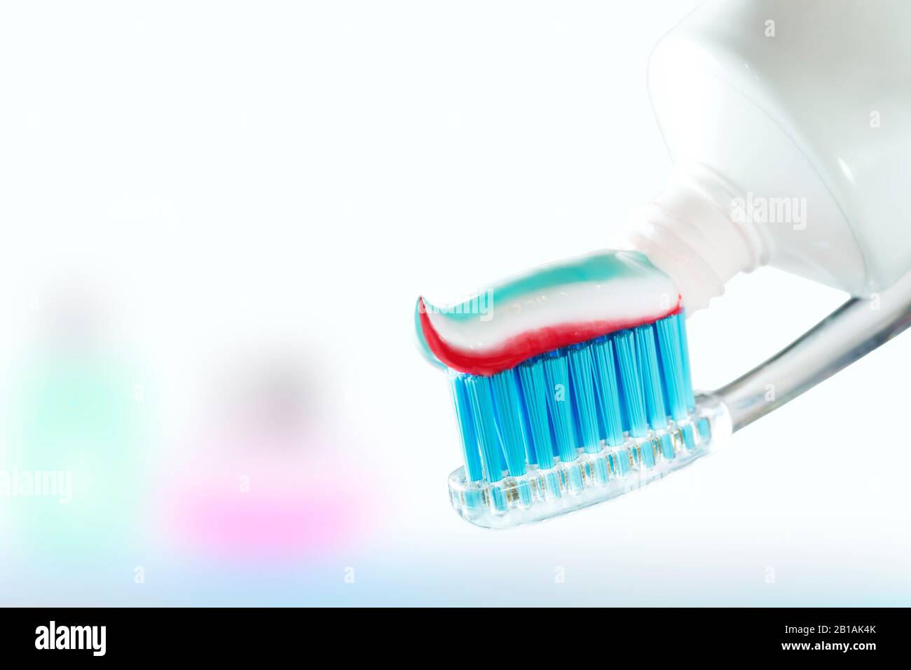 Spazzolino da denti e dentifricio su sfondo sfocato. Attenzione alla cavità orale e al capezzolo Foto Stock