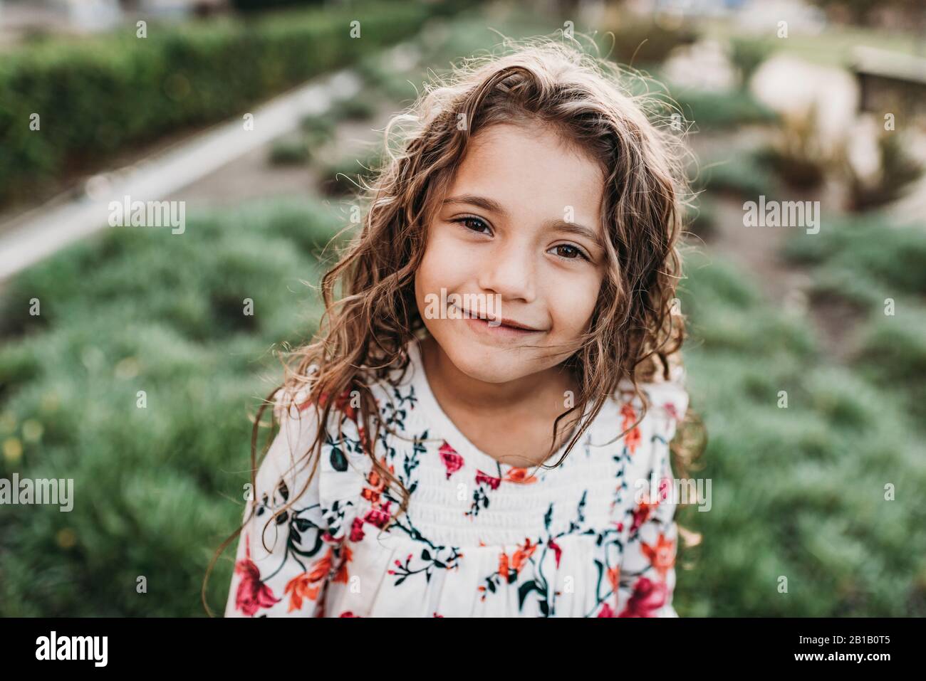 Primo piano ritratto di giovane scuola-età ragazza sicura sorridente a. Foto Stock