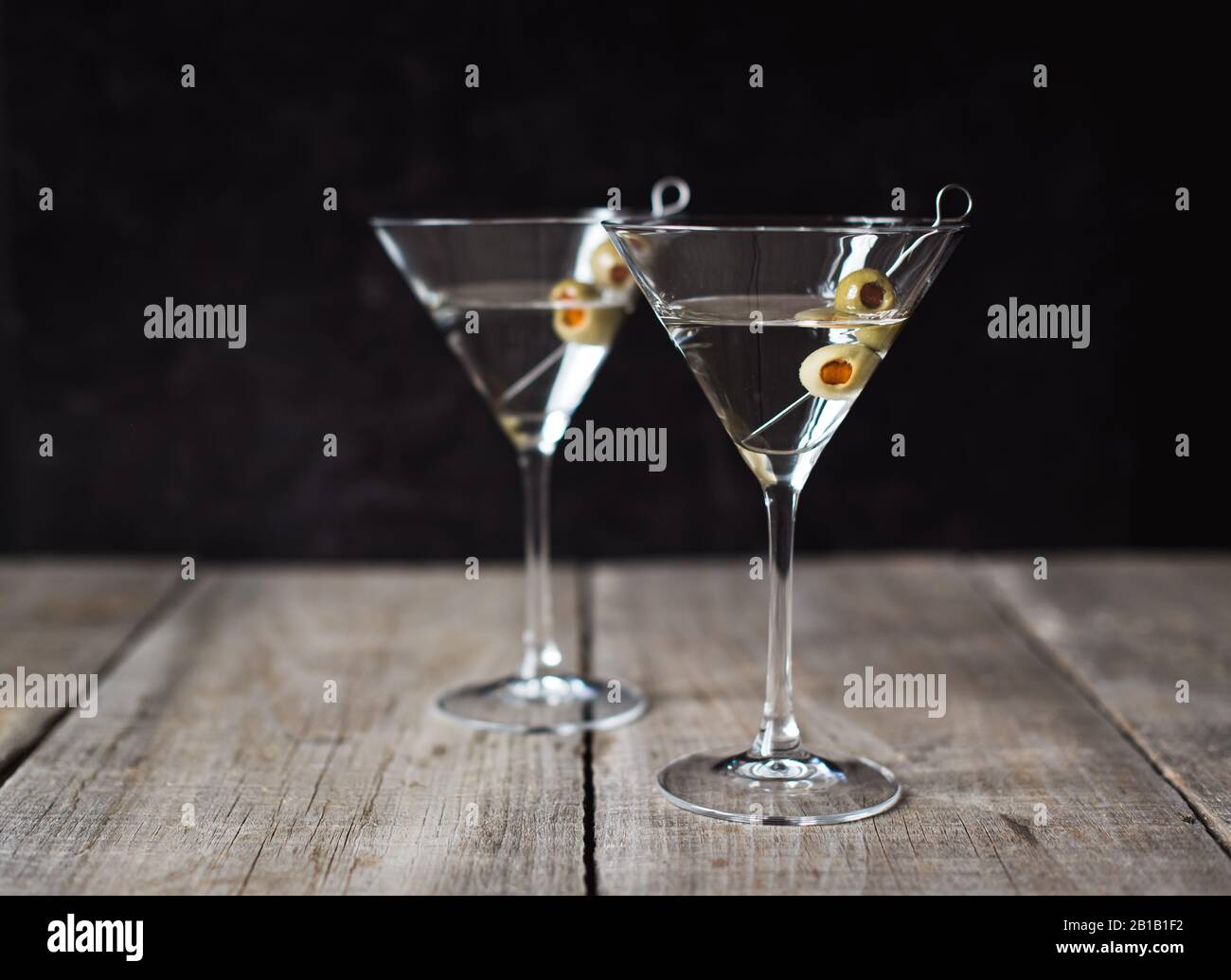 Due classici cocktail martini su tavolo di legno con sfondo nero. Foto Stock