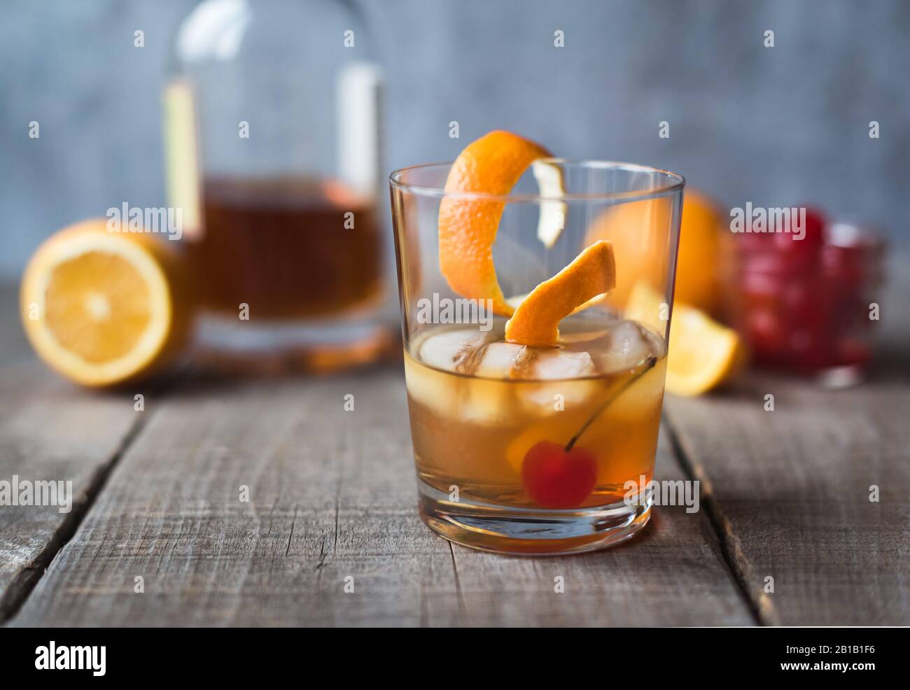 Primo piano di un cocktail vecchio stile con ingredienti sul tavolo di legno. Foto Stock