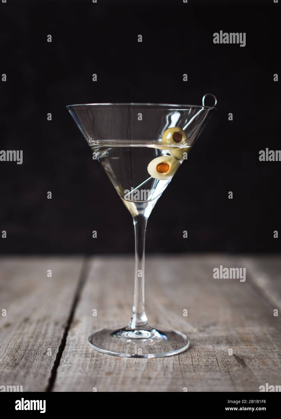 Primo piano di un cocktail martini su tavolo di legno con sfondo nero. Foto Stock