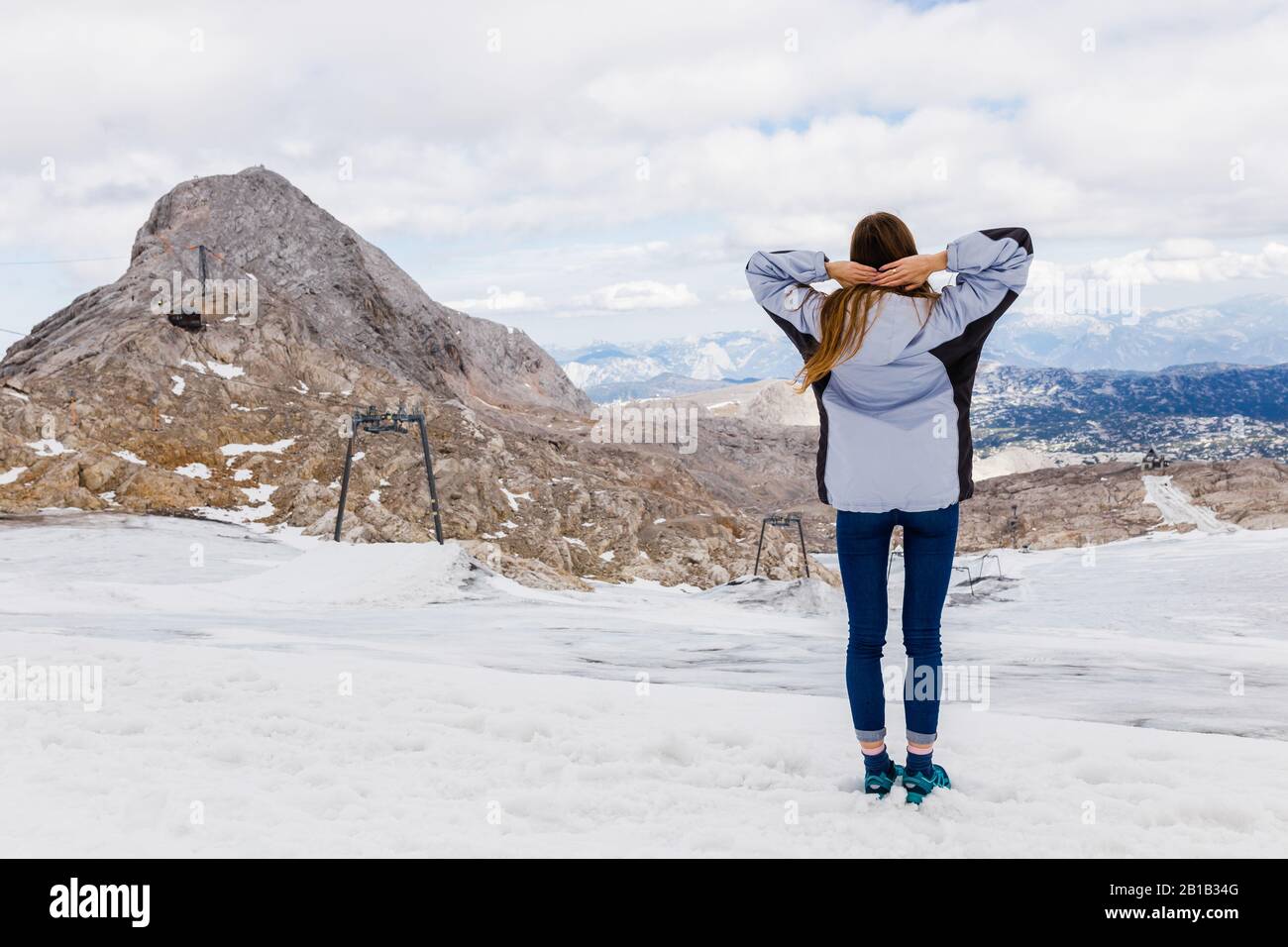 Giovane ragazza millenaria gode della vista sulle Alpi che si erpano sul ghiacciaio Foto Stock