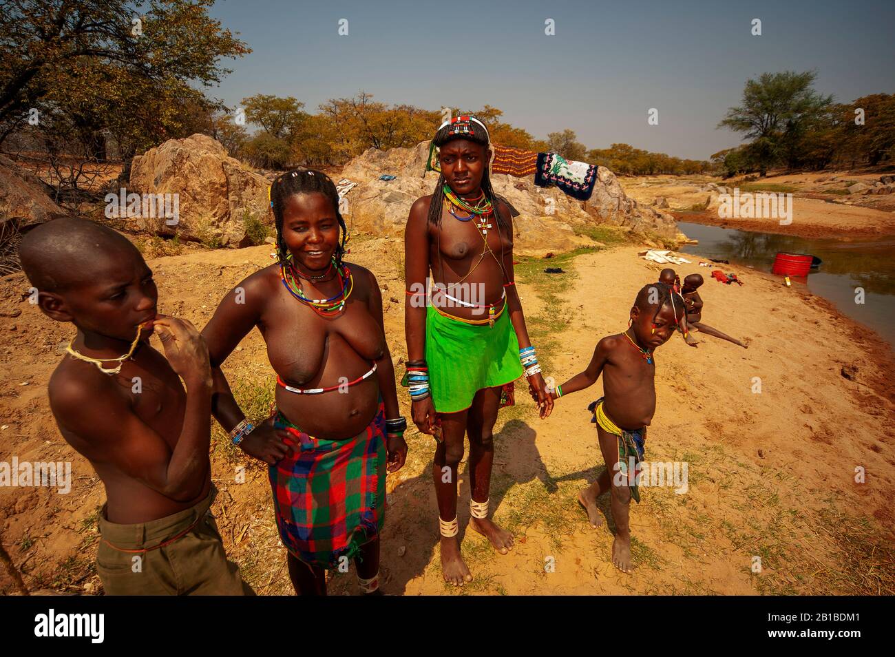 Womans africani lavando vestiti su un piccolo ruscello proprio dalla strada D3701, Kunene Regione, Namibia settentrionale Foto Stock Womans africani lavando vestiti su un piccolo ruscello proprio dalla strada D3701, Kunene Regione, Namibia settentrionale Foto Stock