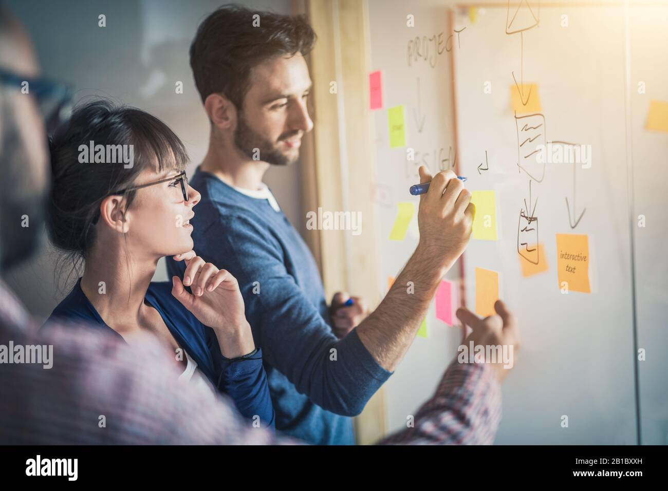 La gente di affari riunione in ufficio e uso di post-it per condividere idea. Concetto di brainstorming. Nota adesiva sulla parete di vetro. Foto Stock