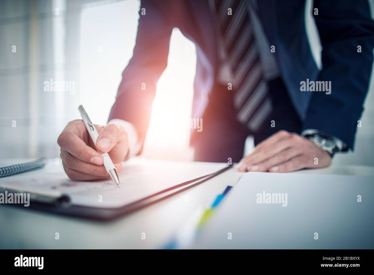 Uomo d'affari che firma il documento di contratto sulla scrivania dell'ufficio, facendo un affare. Foto Stock