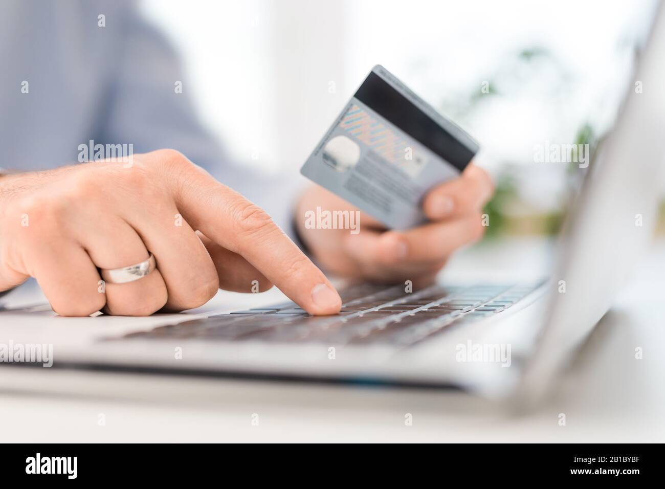 Mani che tengono la carta di credito e che usano il portatile. Pagamento online e concetti di shopping. Foto Stock