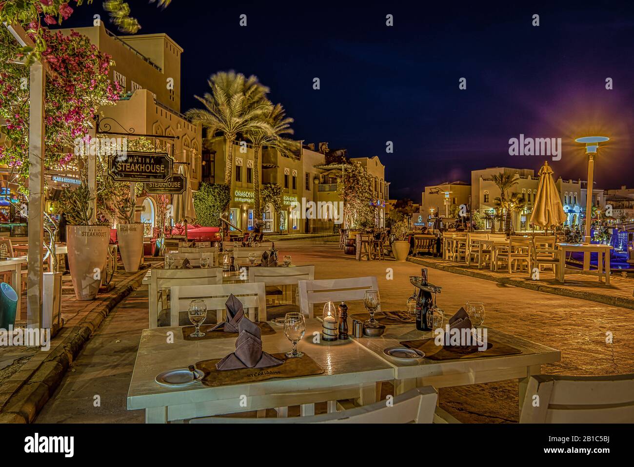 Scena notturna con ristoranti illuminati e tavoli per cena sul marciapiede, el Gouna, Egitto, 17 gennaio 2020 Foto Stock