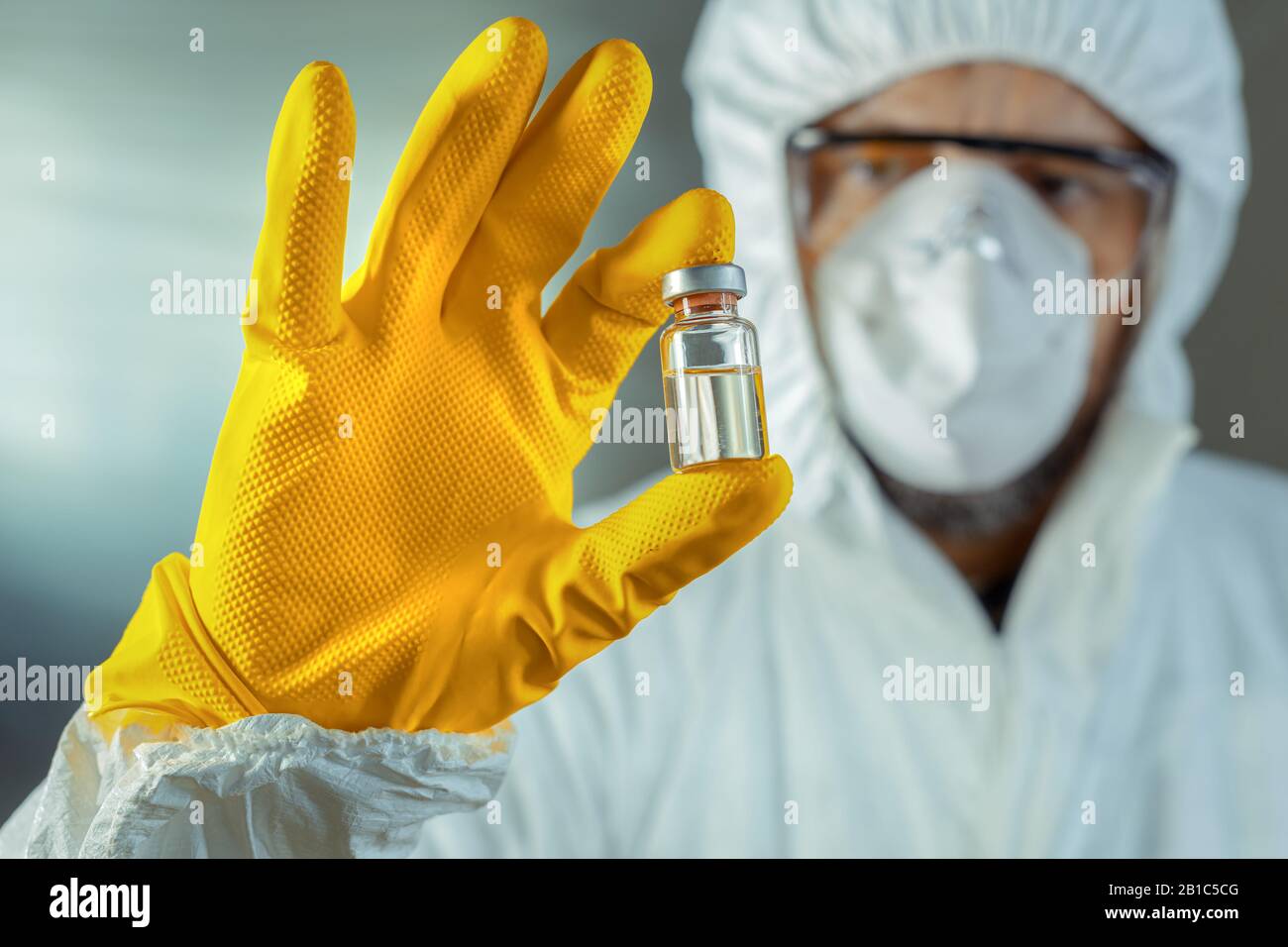 Operatore medico che tiene il flacone sterile di siero di vaccino, fuoco selettivo Foto Stock