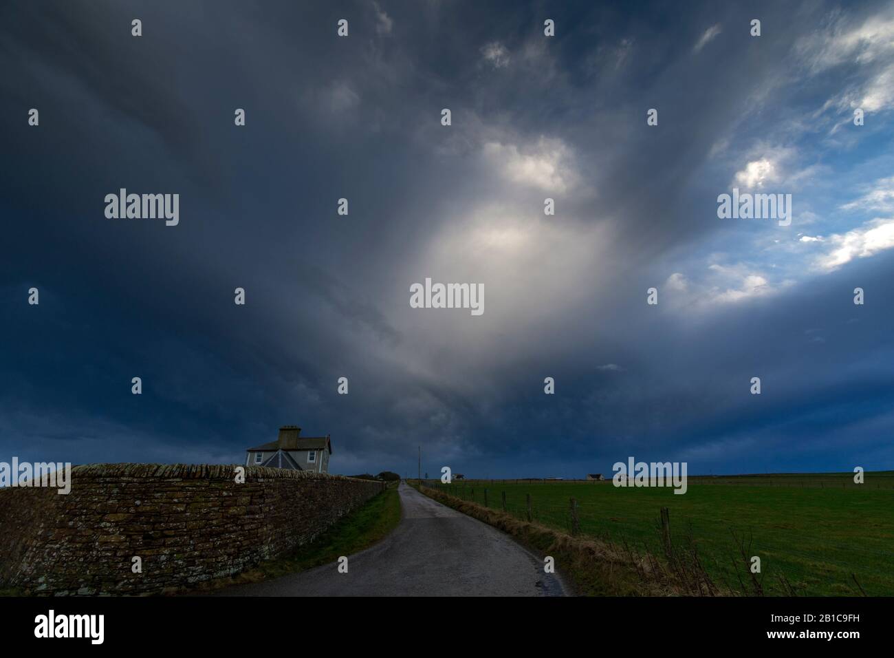 Nuvole drammatiche sopra Seaview House, dalla stretta strada costiera, East Mey, Caithness, Scozia, Regno Unito Foto Stock