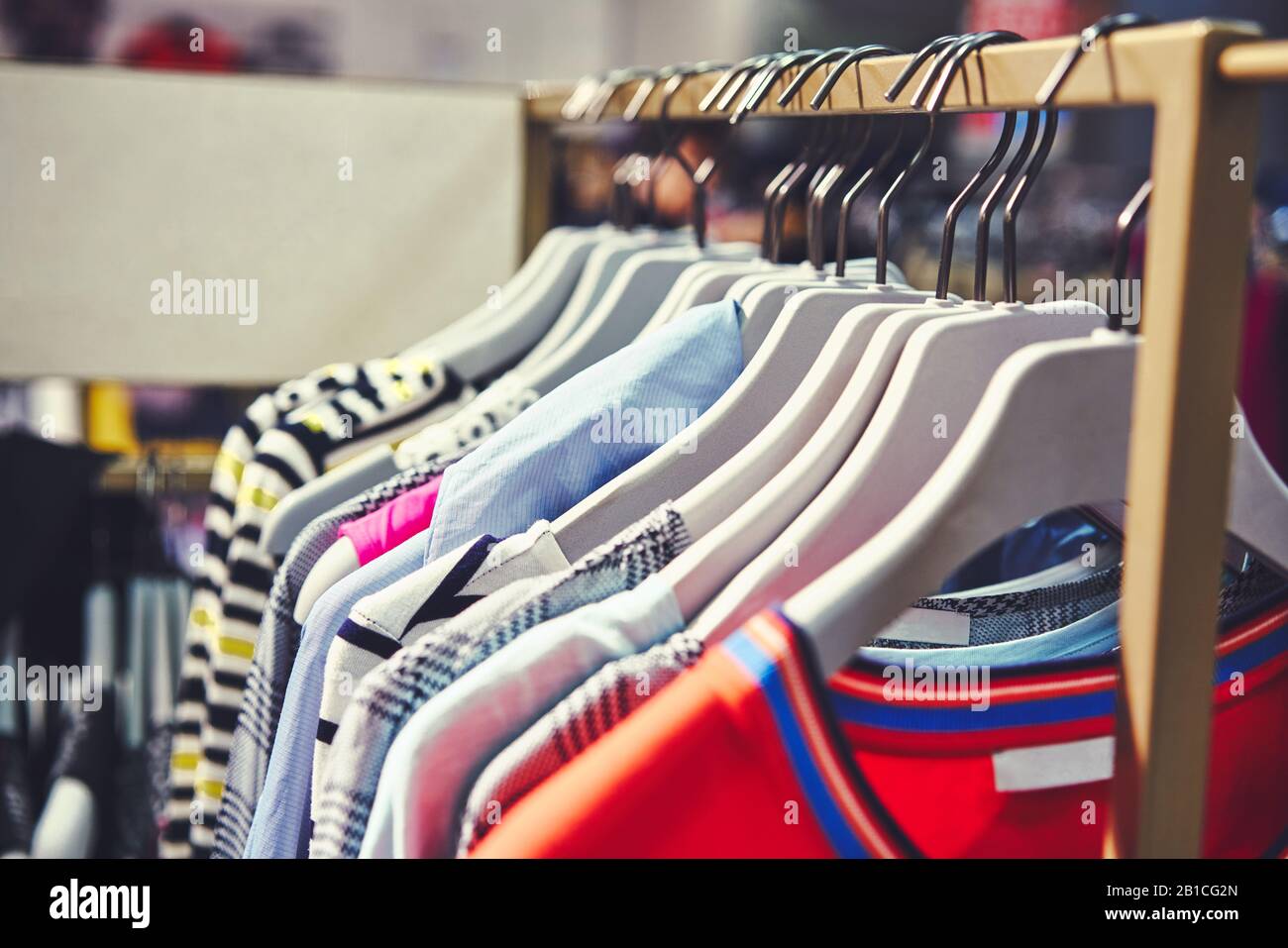 I vestiti appendono su una mensola in un deposito di vestiti del progettista. Vendita abiti Foto Stock
