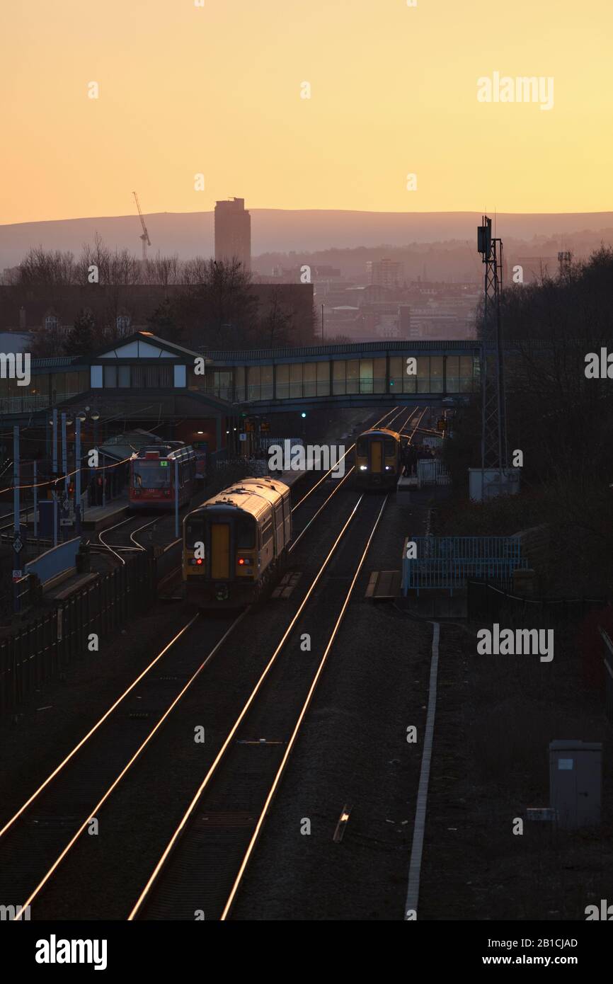 Treni Northern Rail e Stagecoach Sheffield Supertram allo svincolo Meadowhall stazione ferroviaria, South Yorkshire al tramonto Foto Stock