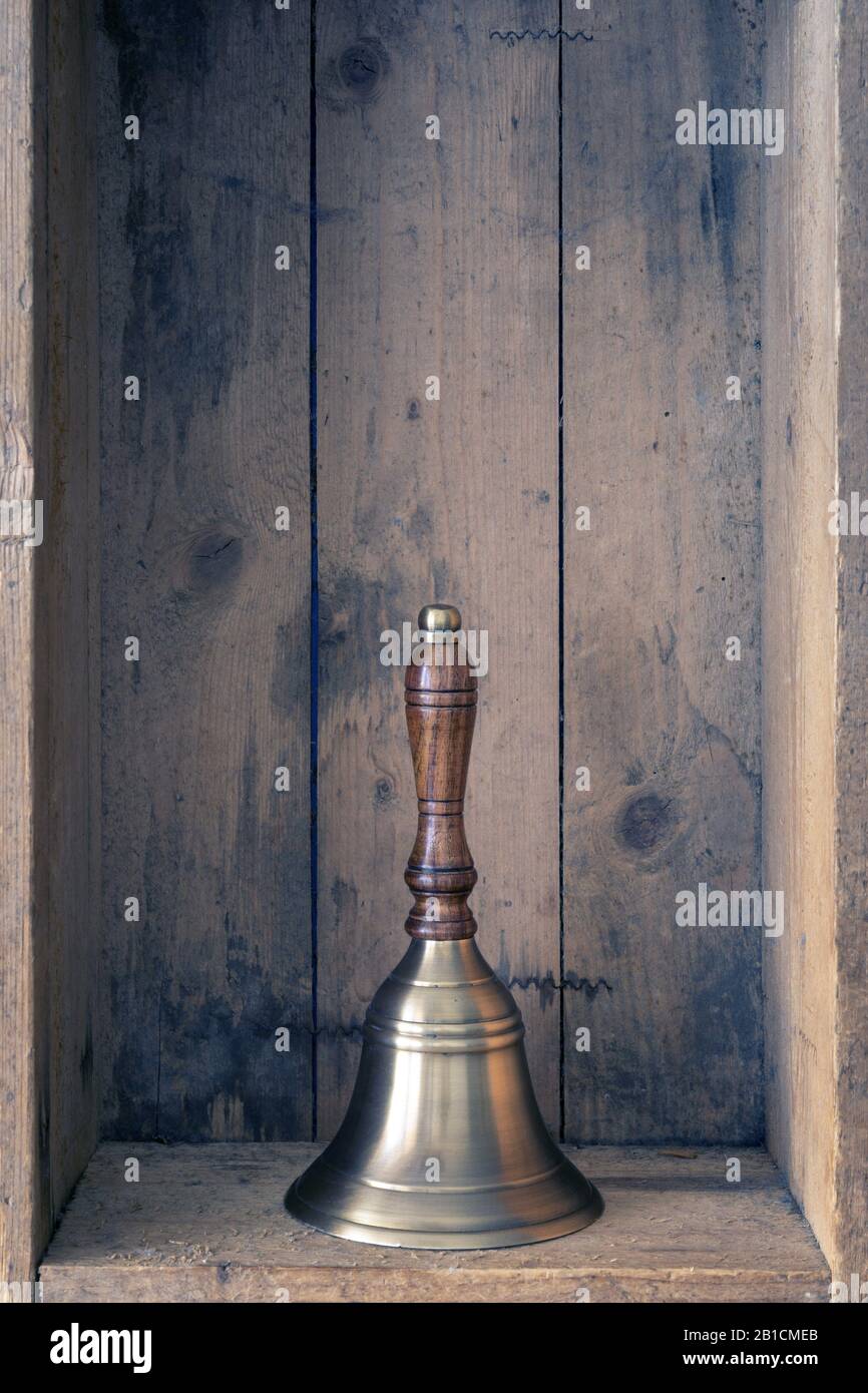 Campanella color bronzo con manico in legno all'interno di una scatola in legno Foto Stock
