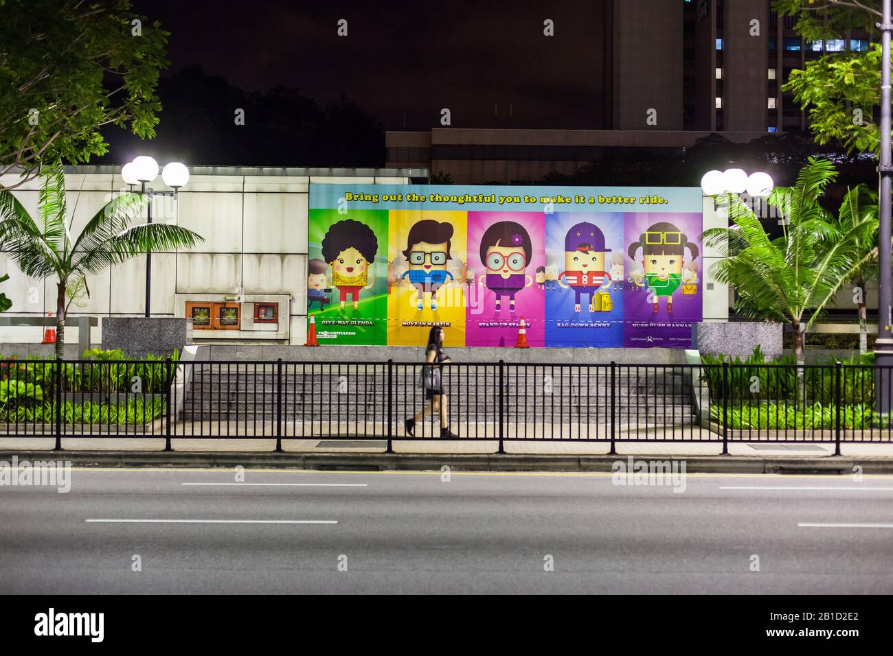 Street scena di una signora cinese passava una fila di poster grafici colorati. Singapore Foto Stock