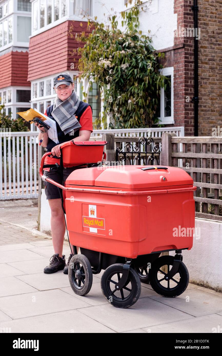 Royal Mail carrier al lavoro con carrello a due passi del destinatario, Chiswick, Londra, Inghilterra Foto Stock