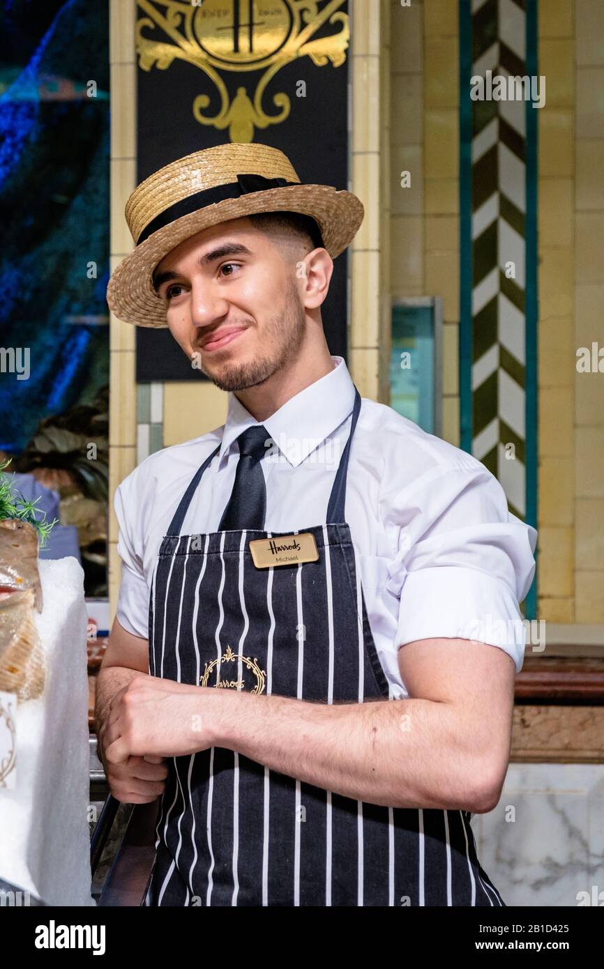 Harrods Food Hall, dipendente al lavoro con un sorriso sul viso. Foto Stock