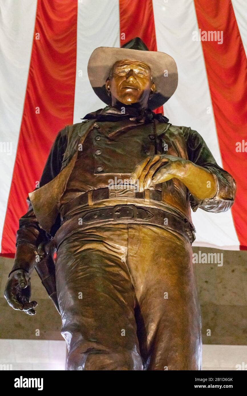 Una statua in bronzo di John Wayne, famoso attore americano, vestito da cowboy, si trova all'aeroporto John Wayne, Orange County, a Santa Ana, California. Foto Stock