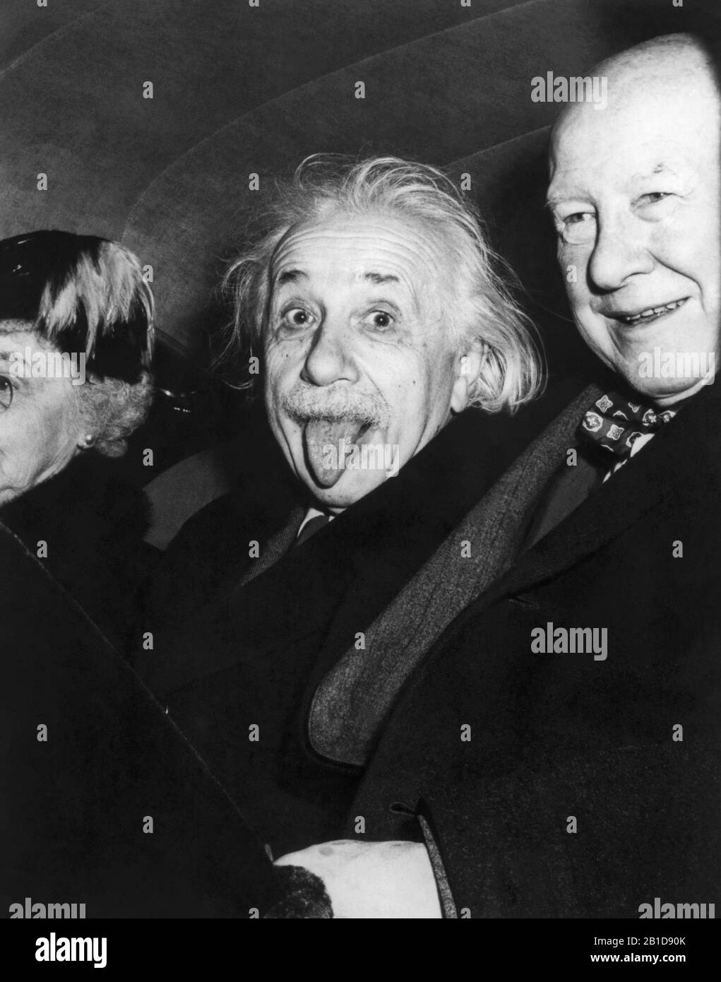 Foto iconica di Albert Einstein che si è bloccato sulla sua lingua in occasione della sua festa di 72nd compleanno alla Princeton University il 14 marzo 1951. Il fotografo Arthur Sasse ha catturato la seconda immagine mentre Einstein stava lasciando l'evento, seduto sul sedile posteriore di una macchina tra il Dr. Frank Aydelotte, ex capo dell'Institute for Advanced Study presso la Princeton University, e la moglie di Aydelotte, Marie Jeanette. Foto Stock