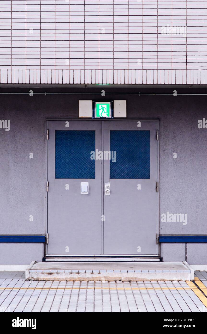 Edificio moderno di uscita di emergenza con ferro metallico porta con fire exit segno sopra la porta Foto Stock