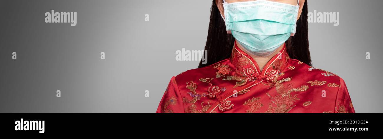 Donna asiatica in costume cinese indossare una maschera igienica con spazio di copia, volto anonimo. La situazione di scoppio di Coronavirus 2019 infezione o Covid-19 Foto Stock