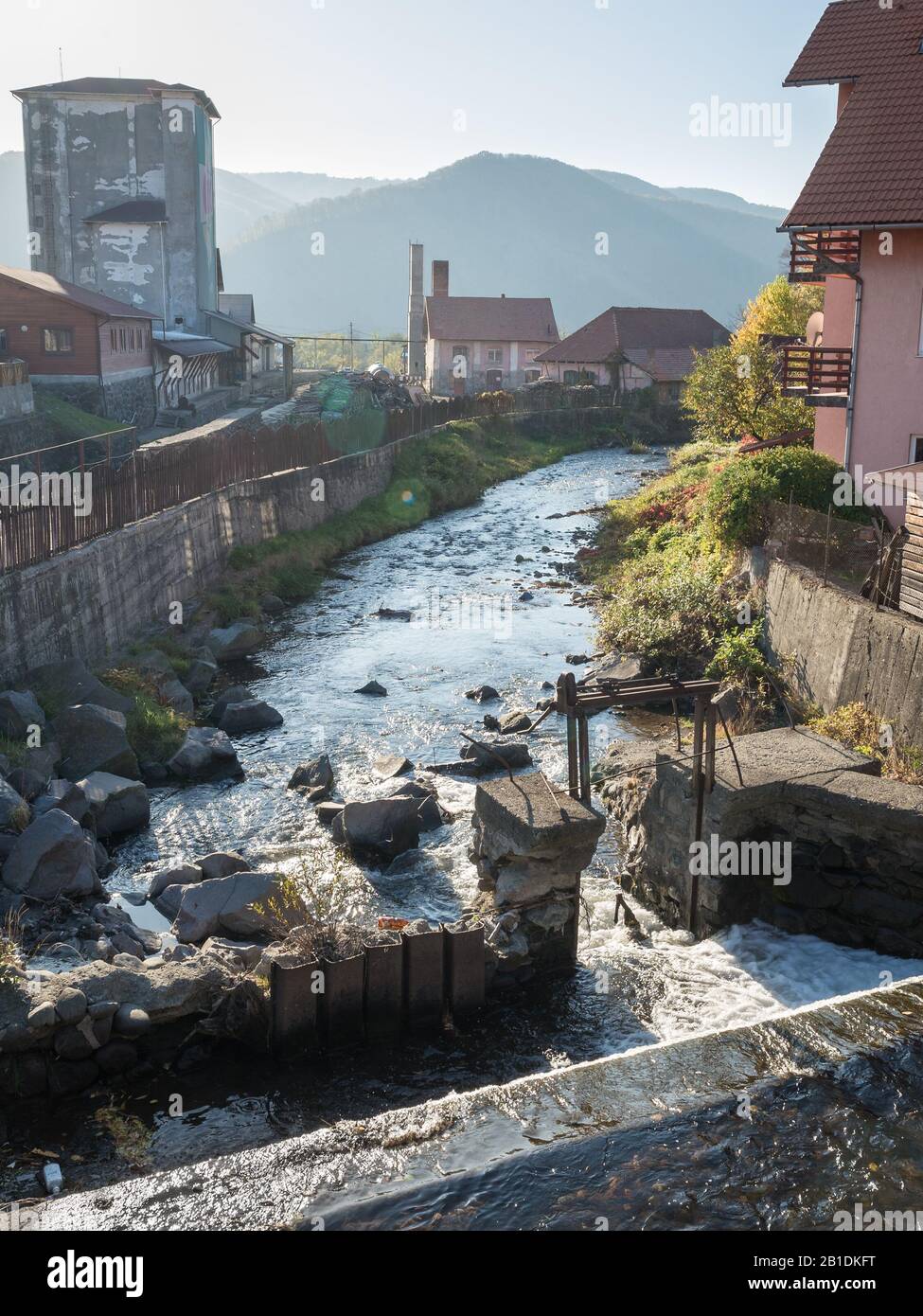 Vista panoramica della vecchia industria lungo un fiume in Romania. Le lenti sono visibili. Foto Stock