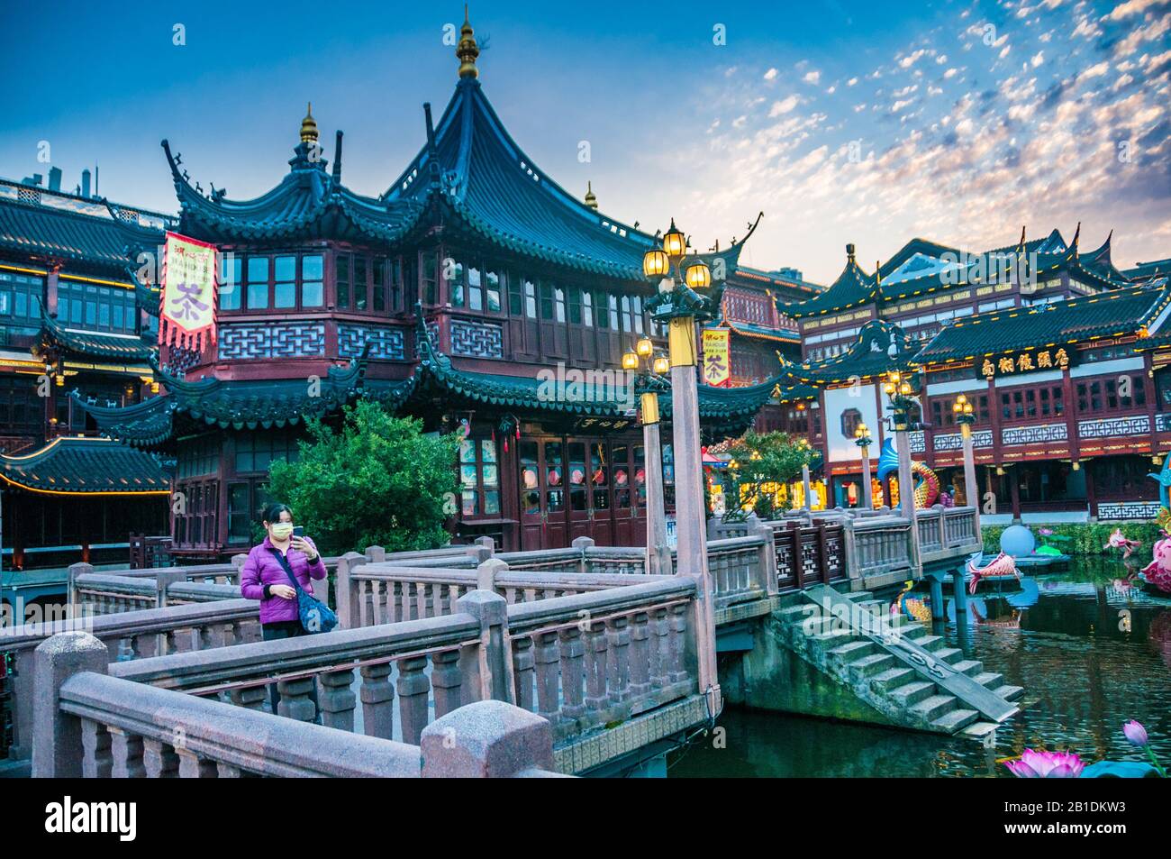 Un turista che indossa una maschera facciale prende un selfie di fronte alla teahouse di Huxinting nello Yuyuan di Shanghai. Foto Stock