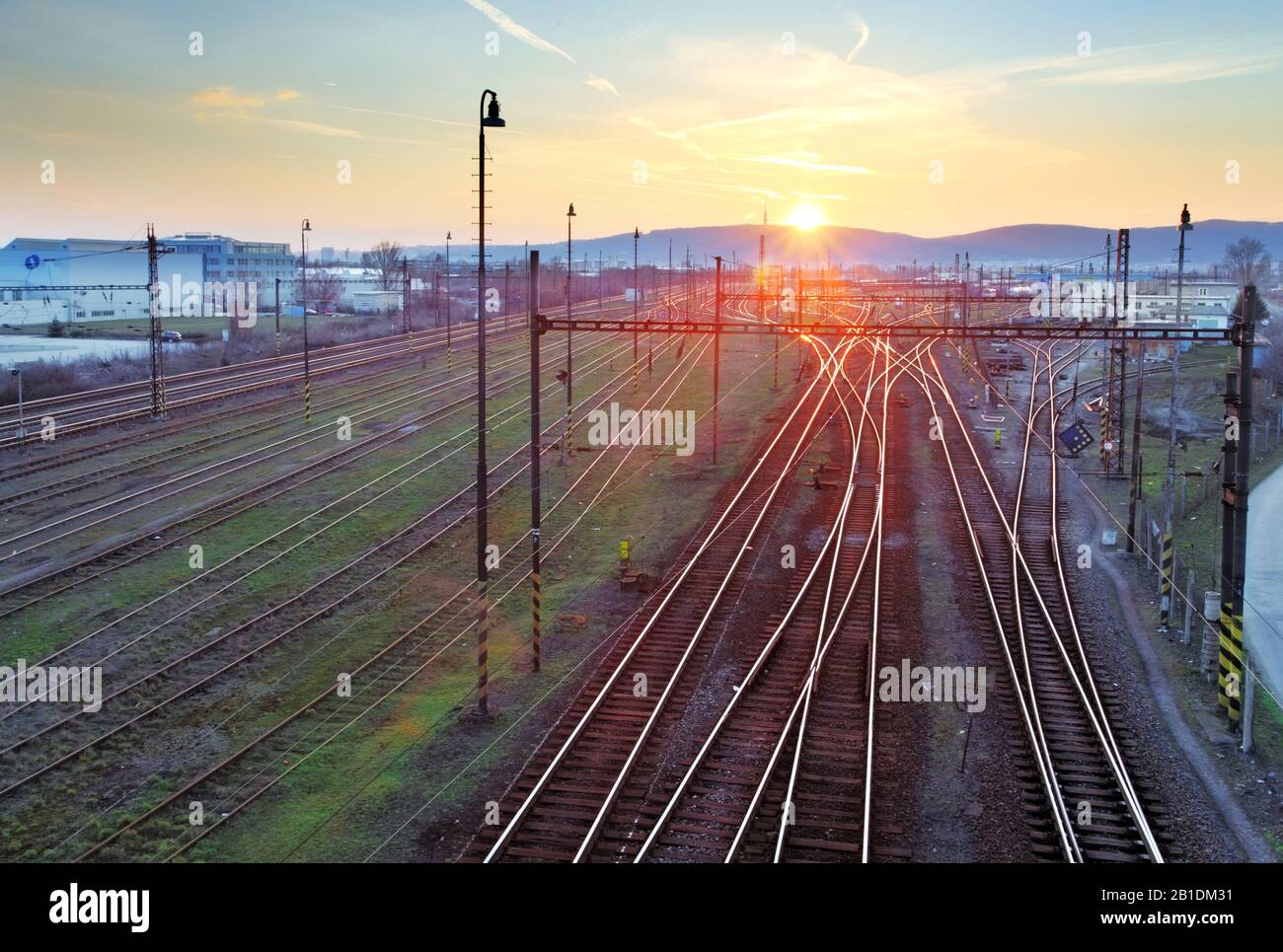 Ferrovia con treno al tramonto e molte linee Foto Stock