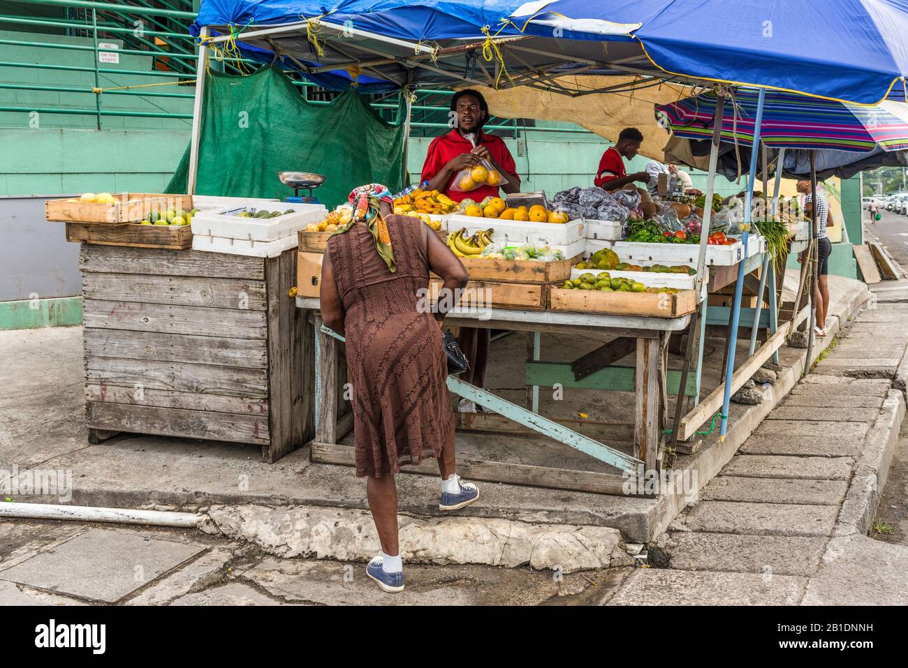 St John's, Antigua e Barbuda - 18 dicembre 2018: Venditori di frutta e verdura fresca in un mercato locale a St. John's, Antigua, West Indies, Caraibi Foto Stock