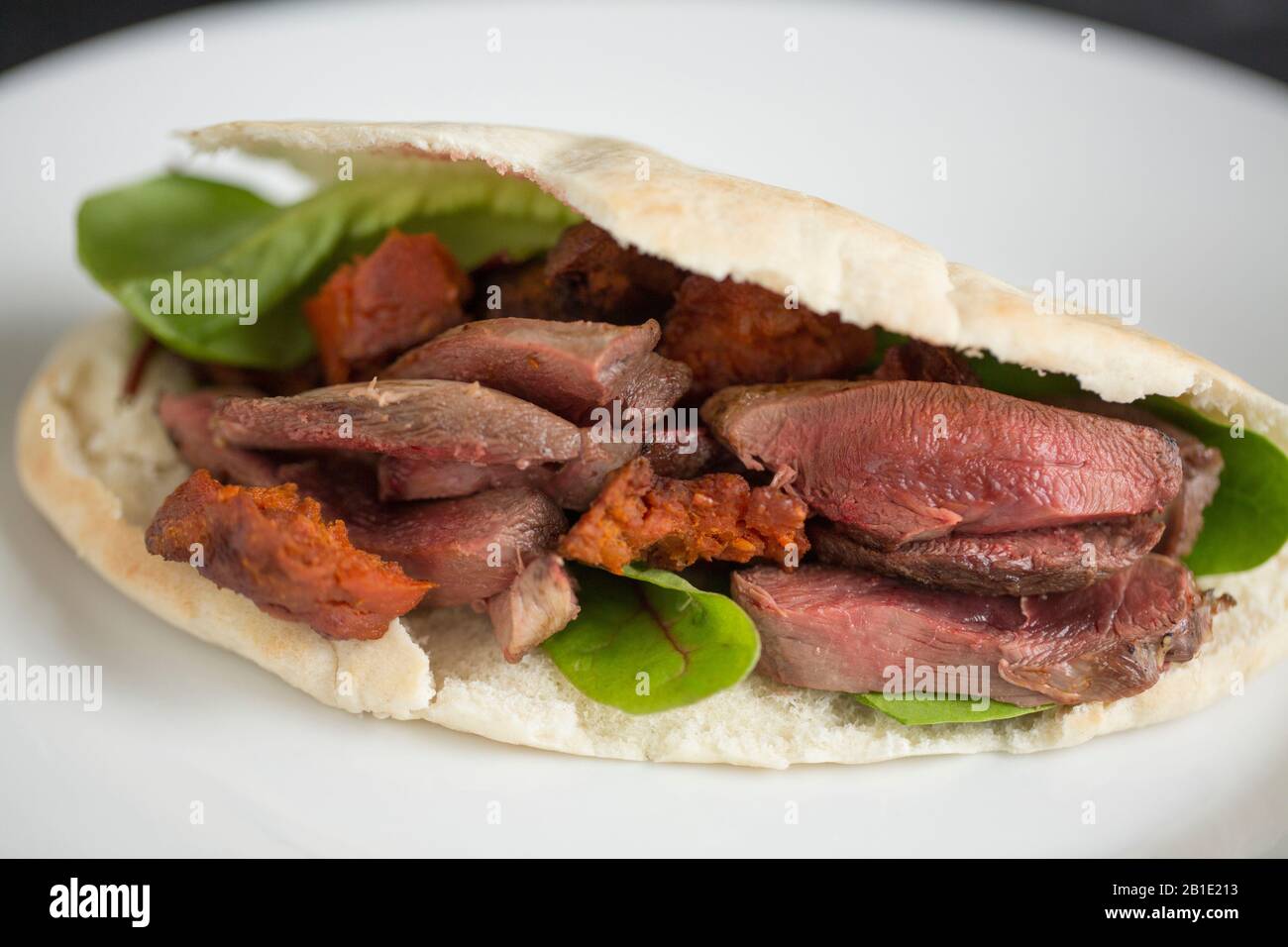 Pane Woodpigeon e chorizo pitta. Il filetto di piccione è stato fritto con il flash per lasciarlo tenero, affettato e poi messo nel pane pitta con choriz fritto Foto Stock