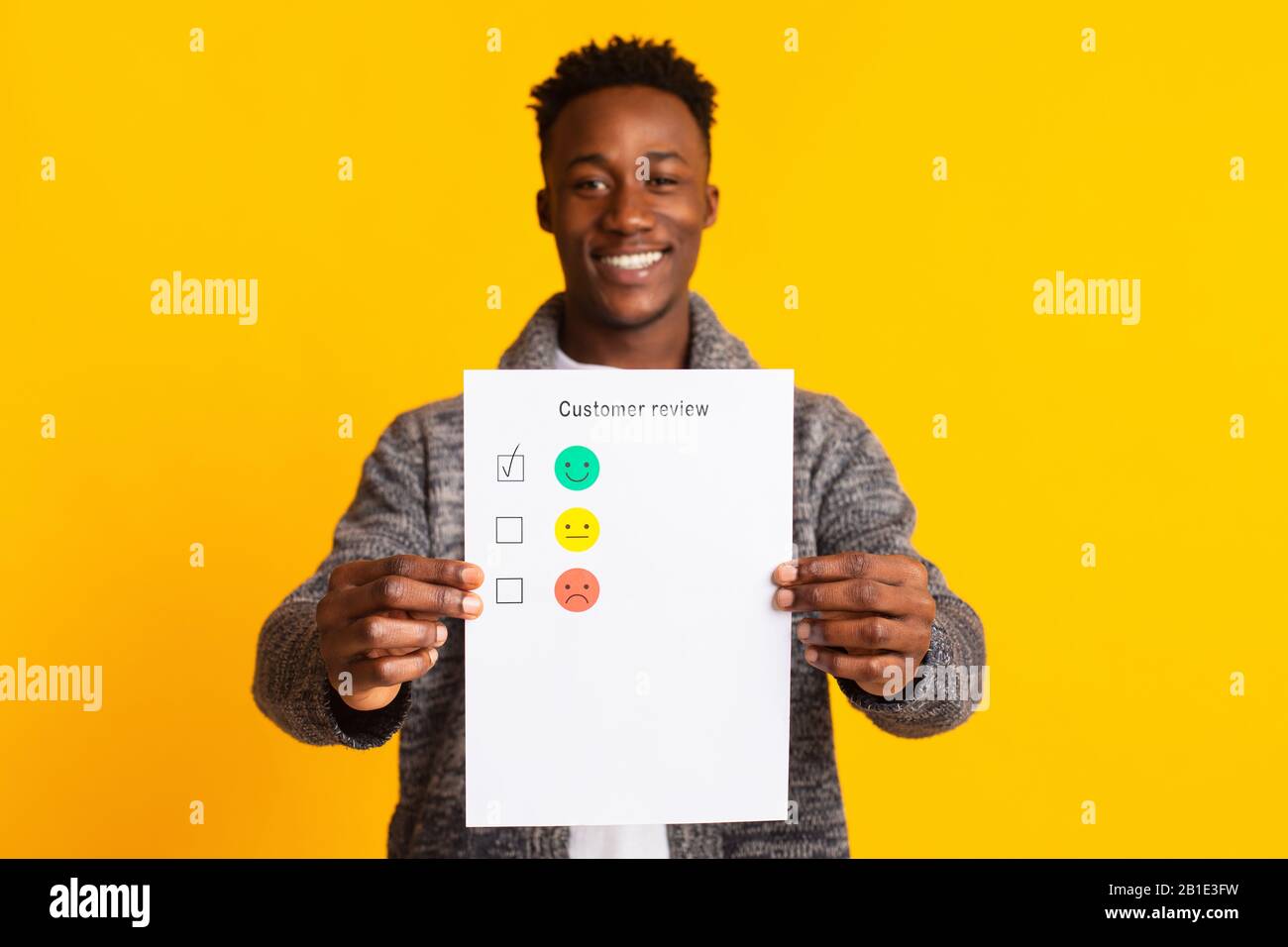 Giovane africano che tiene la revisione del cliente con il feedback eccellente Foto Stock