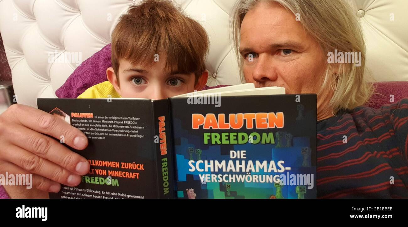 Padre e sole che leggono un libro, Germania, MR=Sì, Foto Stock