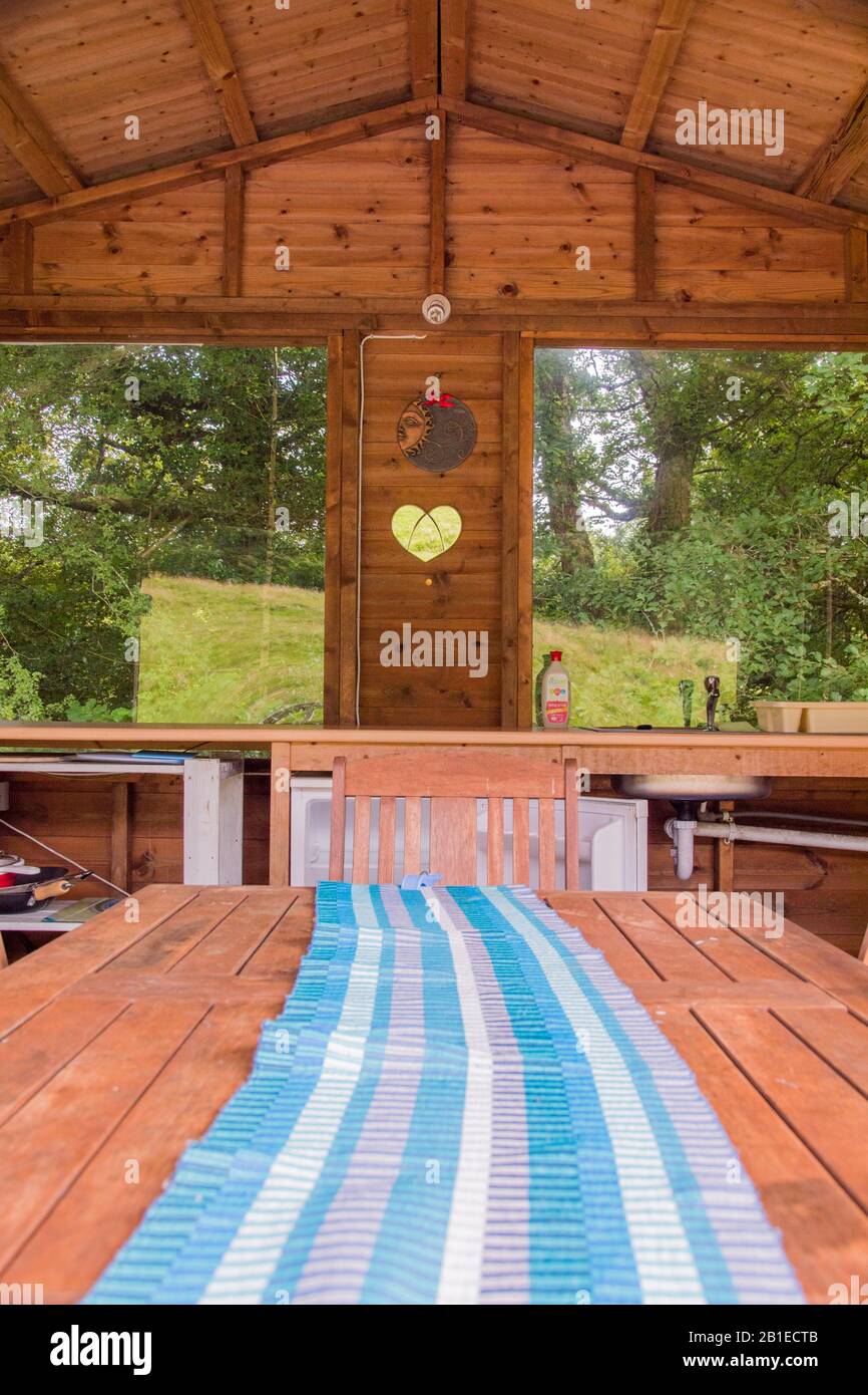 Galles, Regno Unito: 10 ago 2016 : campeggio di lusso o alloggio glamping, con una cucina esterna riparata - patio - cena, ritorno alla natura al ritiro di Seren, Foto Stock