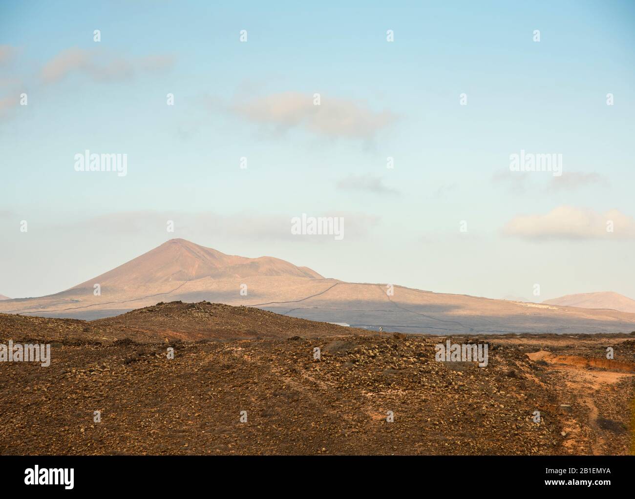 Vista del vecchio vulcano dall'altra parte del paesaggio arido delle Isole Canarie di Lanzarote Spagna. Foto Stock