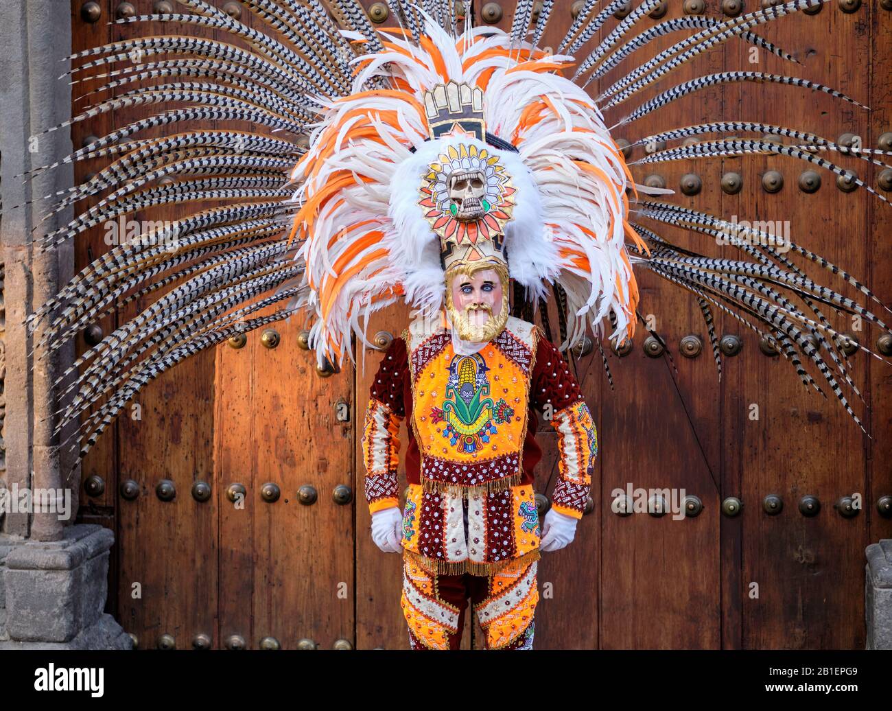 Ritratto di ballerino indossando maschera con cranio e piume, una ballerina in Una Cucciolata di Huehues in costumi tradizionali messicani al Carnevale di Tlaxcala. Foto Stock