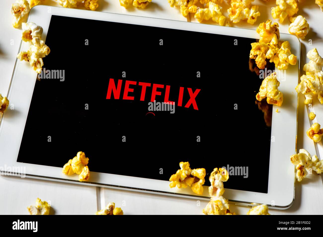 Barcellona, SPAGNA - 24 FEBBRAIO 2016: Popcorn e un tablet con la home page Netflix sullo schermo. Il fornitore di film in streaming e TV Foto Stock