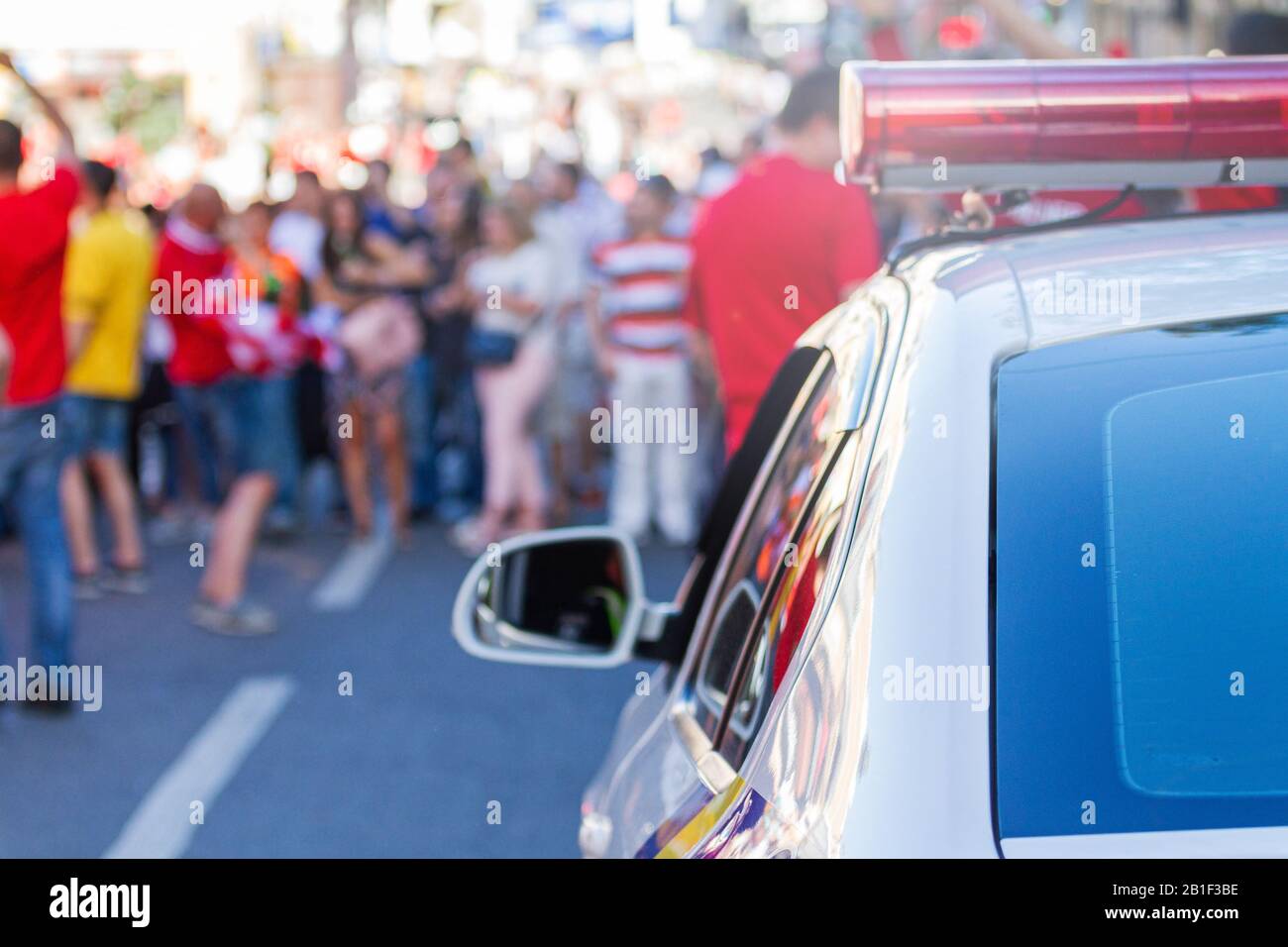 la macchina della polizia tira su ad una folla di manifestanti Foto Stock