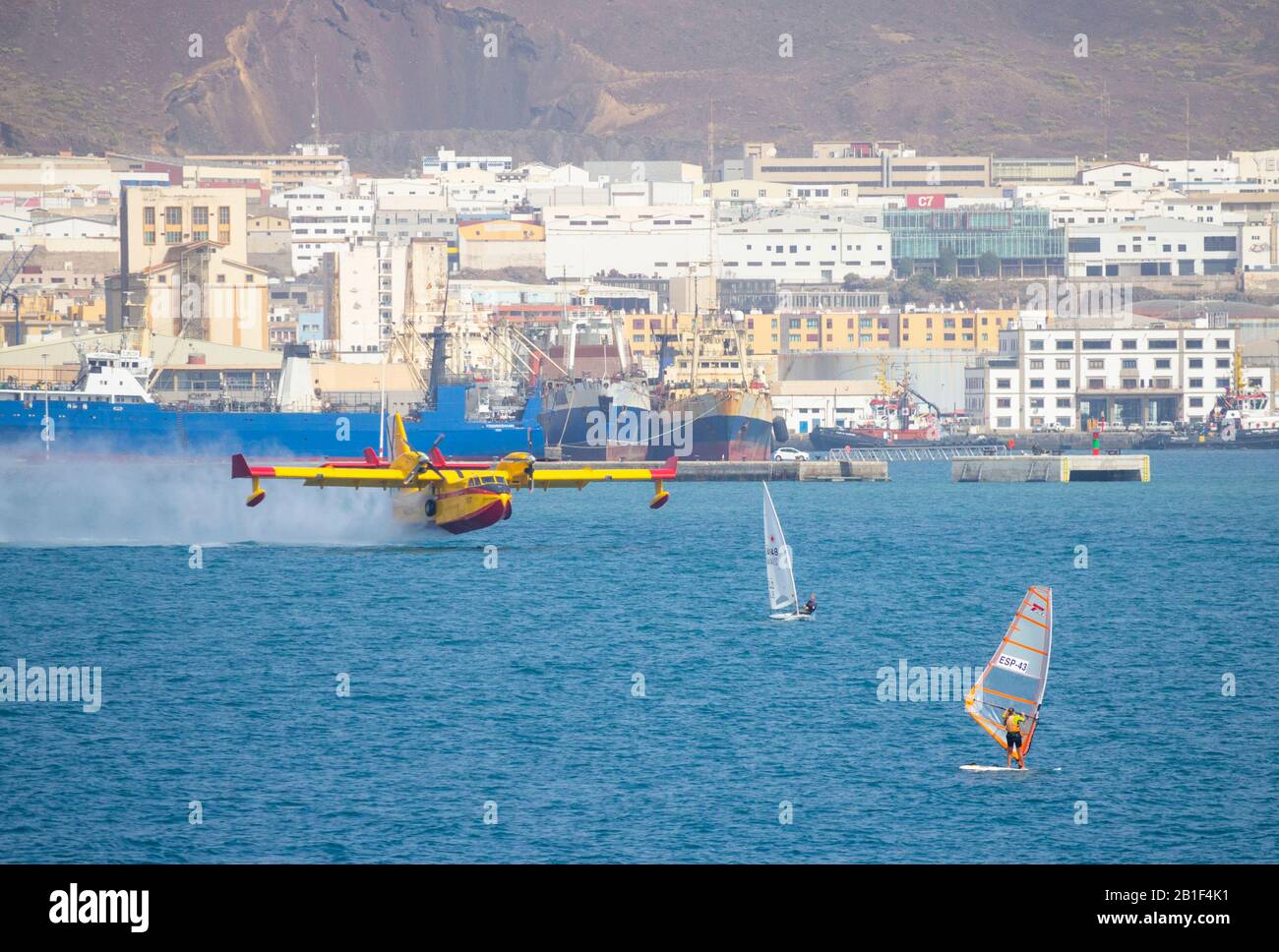 Las Palmas, Gran Canaria, Isole Canarie, Spagna. 25th febbraio 2020. Un bombardiere Canadair CL-215 in idrovolante/acqua sfiora il mare per raccogliere l'acqua nel porto di Las Palmas, mentre due aerei arrivano a Gran Canaria per aiutare a spegnere un incendio della foresta di montagna. Credito: Alan Dawson/Alamy Live News Foto Stock