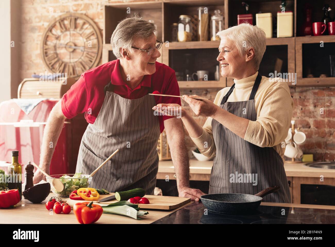 Felice anziani coppia cucina pranzo in cucina insieme Foto Stock
