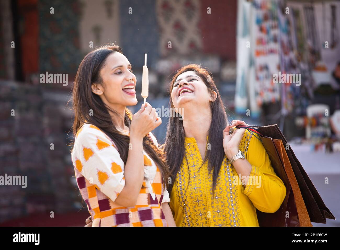 Due donne che mangiano gelati al mercato Foto Stock