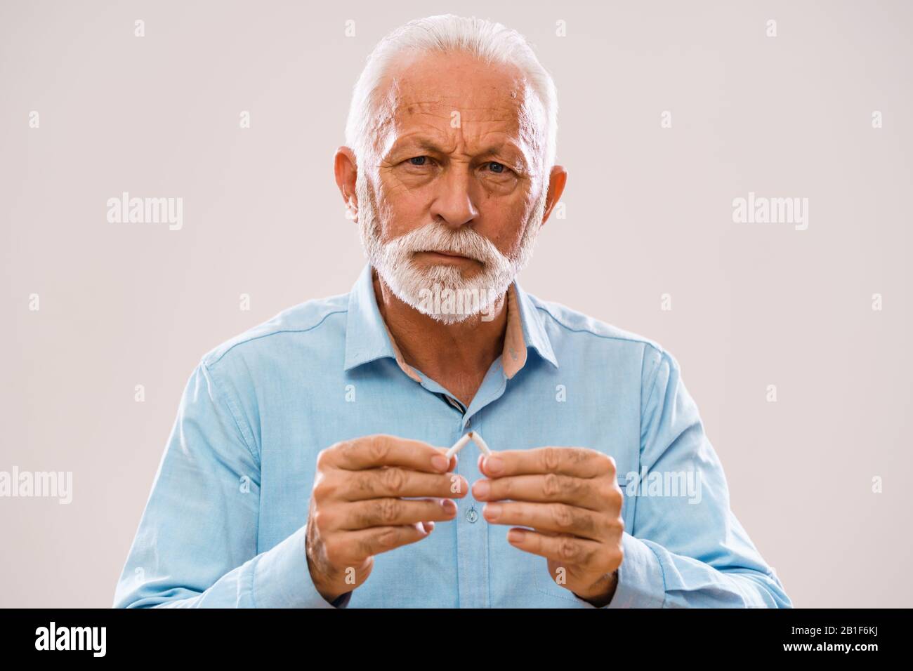 Ritratto di uomo anziano serio che è deciso di smettere di fumare. Foto Stock