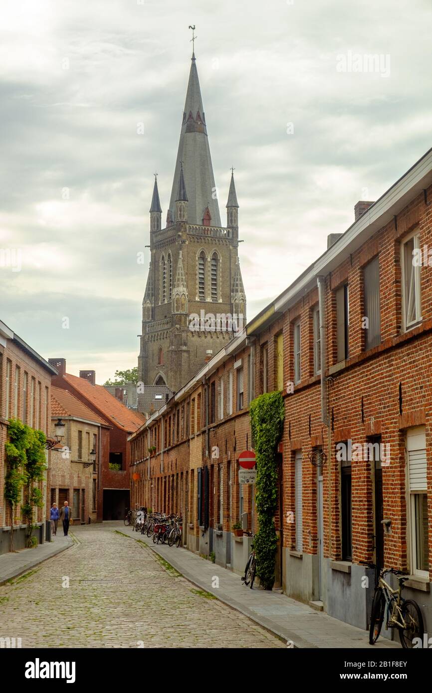 Con un'altezza di 122 metri, la Chiesa Di Nostra Signora domina lo skyline di Bruges. In primo piano, una strada lunga e tranquilla conduce a questo punto di riferimento. Foto Stock Con un'altezza di 122 metri, la Chiesa Di Nostra Signora domina lo skyline di Bruges. In primo piano, una strada lunga e tranquilla conduce a questo punto di riferimento. Foto Stock