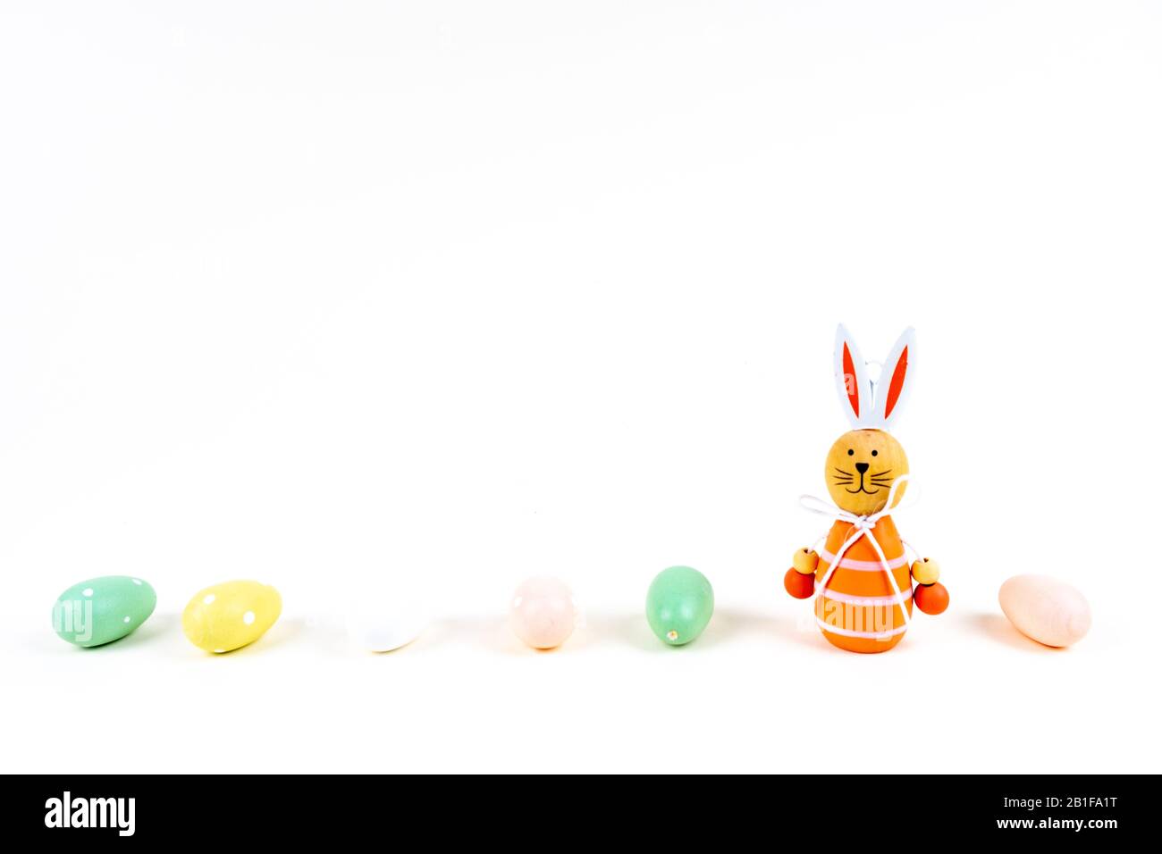 Primo piano di alcune colorate uova di pasqua e un coniglietto di pasqua su sfondo bianco con spazio copia Foto Stock