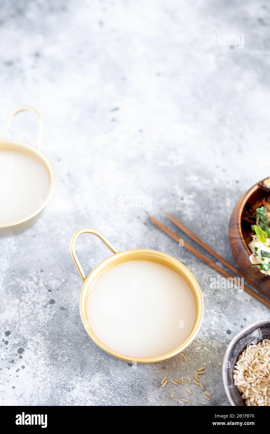 Il vino di riso Makgeolli è una delle più antiche bevande alcoliche tradizionali coreane fermentate. Bevanda sana asiatica. Orientamento verticale, vista dall'alto Foto Stock