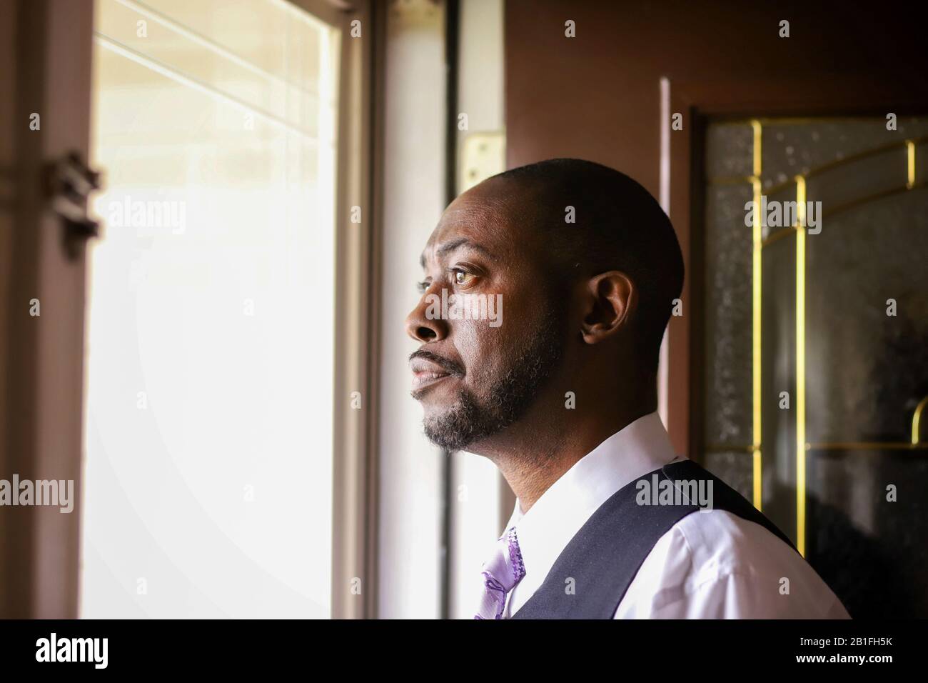Un ritratto di un uomo afro-americano che guarda all'aria aperta a casa Foto Stock